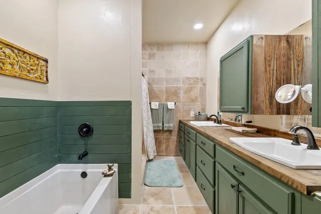 a bathroom with a tub sink and mirror