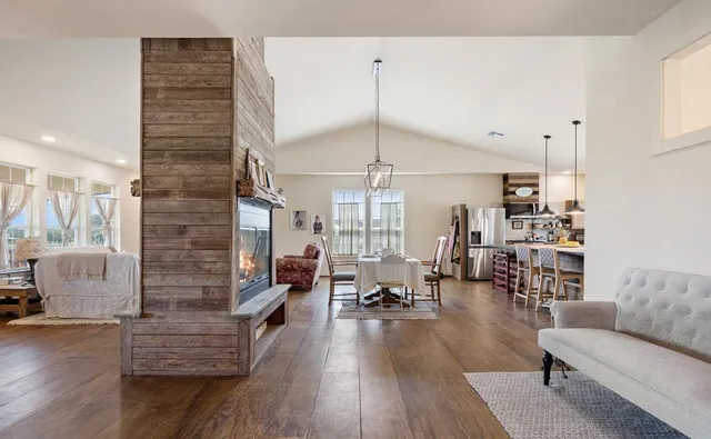 a living room with fireplace furniture and a wooden floor