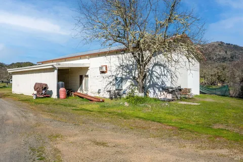 a view of a house with backyard and trees