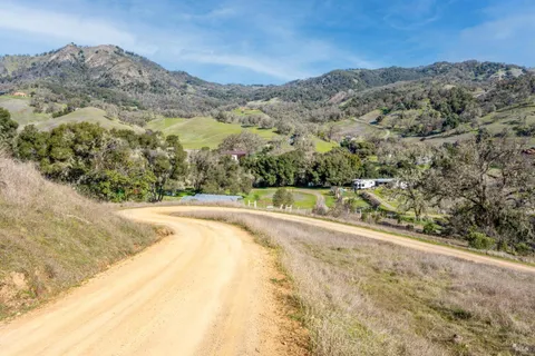 a view of a dry yard with mountains in the background