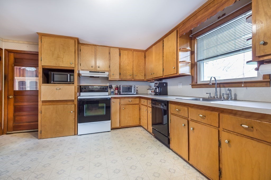 29 Thistle Road Woburn, MA 01801 - Photo 8 of 20 a kitchen with stainless steel appliances granite countertop a stove a sink and a refrigerator