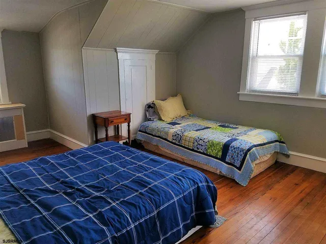 a bedroom with two beds and a window