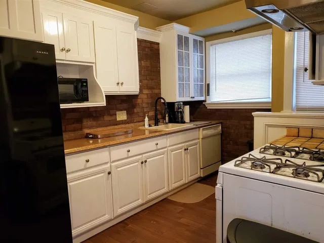 a kitchen with stainless steel appliances a stove a sink and a refrigerator