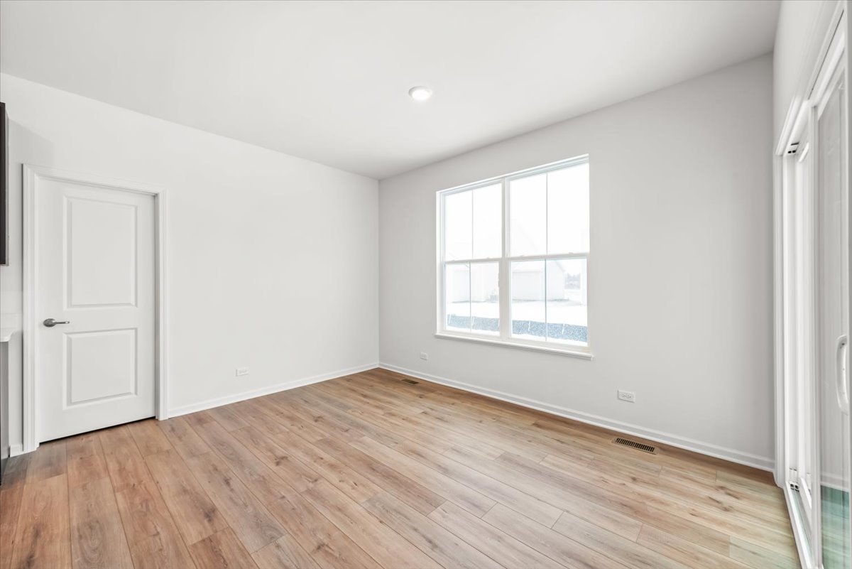 102 Hedgerow Drive Elgin, IL 60124 - Photo 11 of 48 an empty room with wooden floor and windows