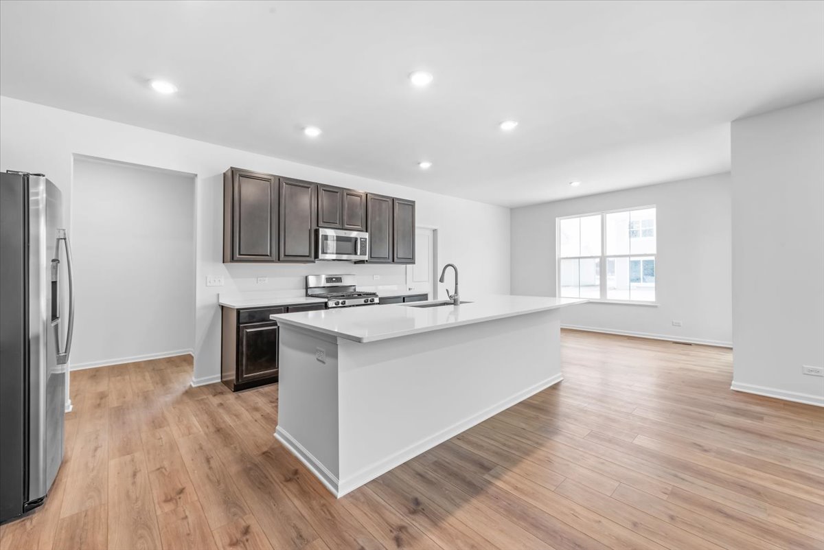 102 Hedgerow Drive Elgin, IL 60124 - Photo 3 of 48 a large kitchen with stainless steel appliances granite countertop a large counter top a sink dishwasher a refrigerator and cabinets with wooden floor