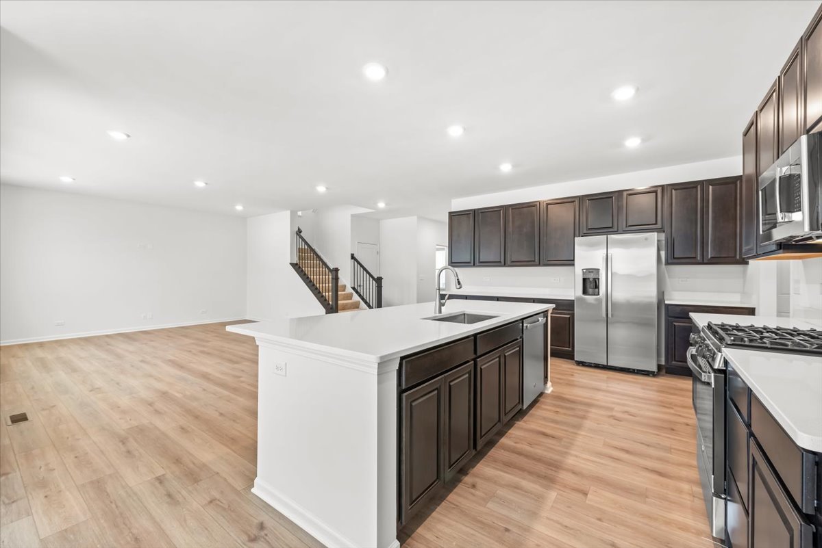 102 Hedgerow Drive Elgin, IL 60124 - Photo 6 of 48 a large kitchen with stainless steel appliances granite countertop a large counter top and a sink