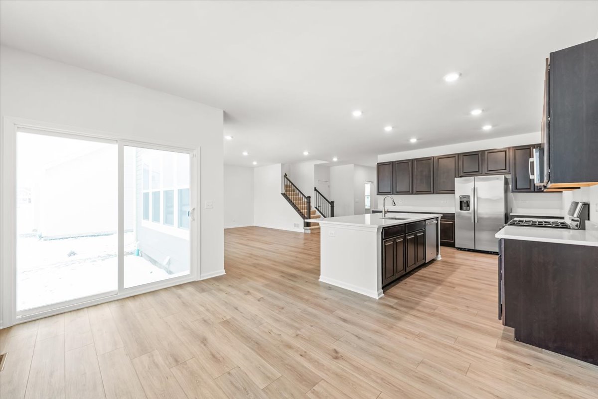102 Hedgerow Drive Elgin, IL 60124 - Photo 7 of 48 a kitchen with stainless steel appliances a stove top oven a sink and a refrigerator