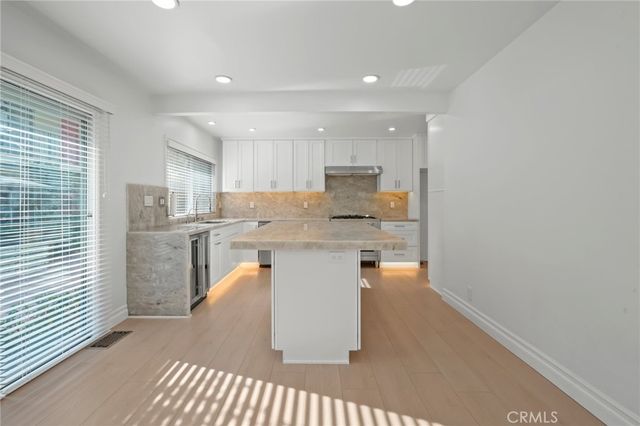a kitchen with a sink a counter top space cabinets and stainless steel appliances