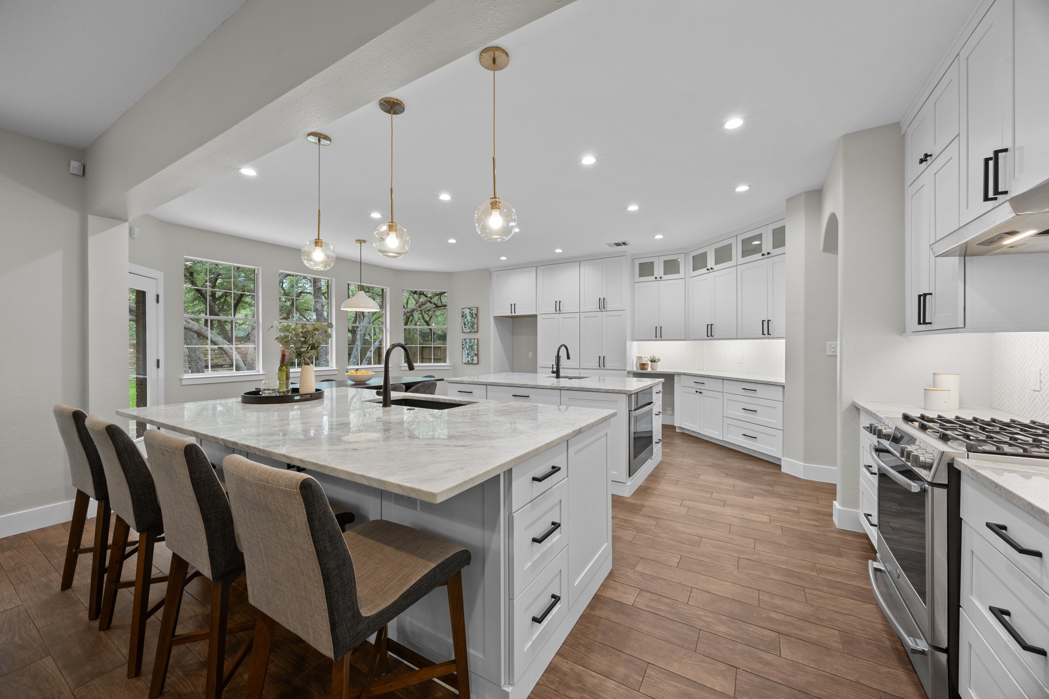 6900 Magenta Lane Austin, TX 78739 - Photo 12 of 40 a kitchen with stainless steel appliances kitchen island granite countertop a table chairs sink and cabinets
