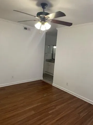 a view of a room with wooden floor fan and window
