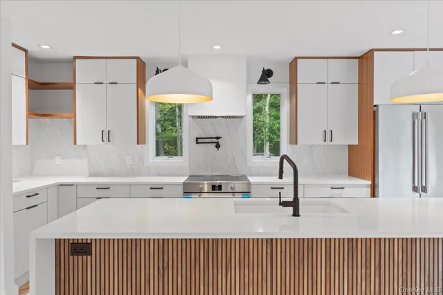 a kitchen with stainless steel appliances a sink a stove and a refrigerator