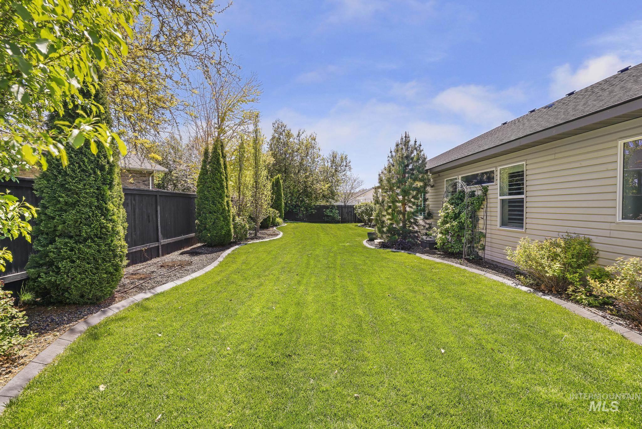 1937 Tamarack Loop Twin Falls, ID 83301 - Photo 43 of 50 Expansive backyard featuring a lush lawn, established perimeter landscaping, decorative curbing, and a dark privacy fence