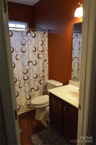 a bathroom with a granite countertop toilet and a shower curtain