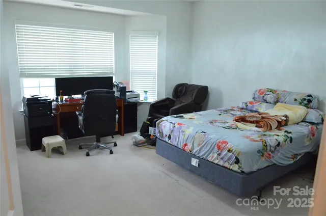 a bedroom with a bed and windows