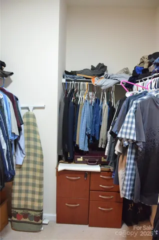 a view of walk in closet with clothes and shoes