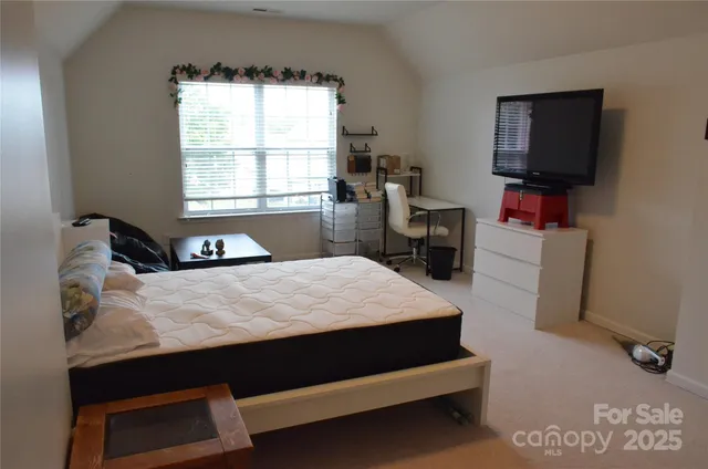 a bed sitting in a bedroom next to a window