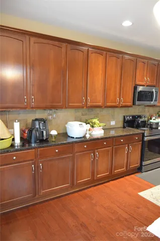 a kitchen with granite countertop wooden cabinets a sink and dishwasher