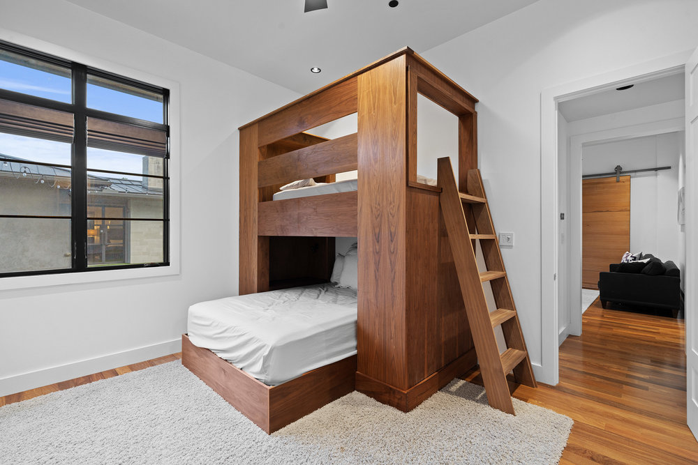 1905 Paisano Road Austin, TX 78746 - Photo 27 of 40 Custom-built wooden bunk beds provide functional and stylish sleeping arrangements in this inviting space.