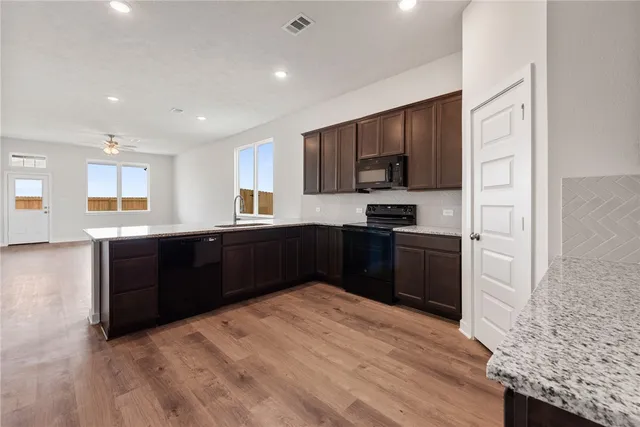 a view of a big room with wooden floor and a ceiling fan