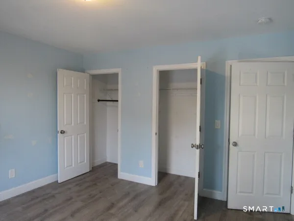 an empty room with wooden floor and closet