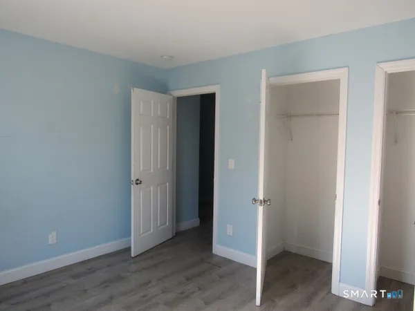 an empty room with wooden floor and closet