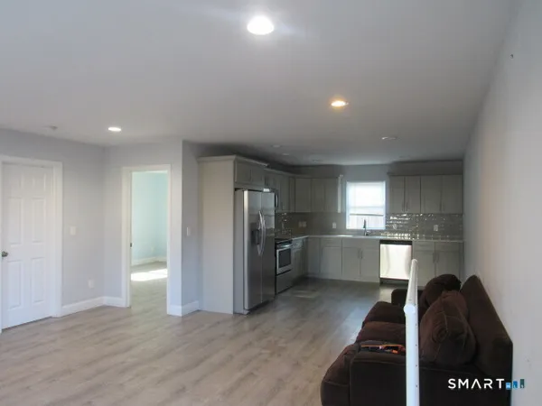 a view of a kitchen with refrigerator stove and wooden floor