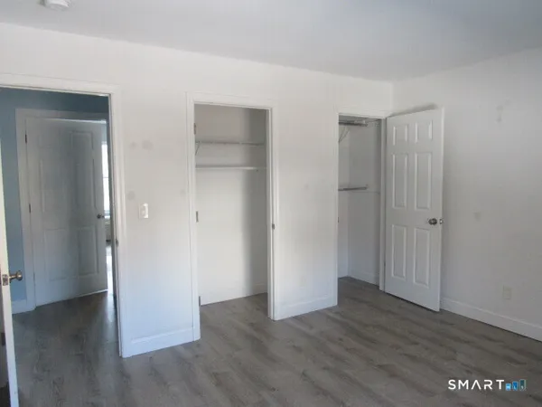 an empty room with wooden floor & closet area