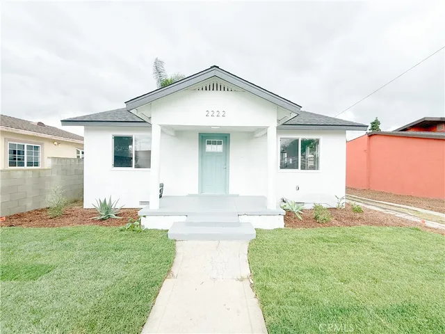a backyard of a house with table and chairs