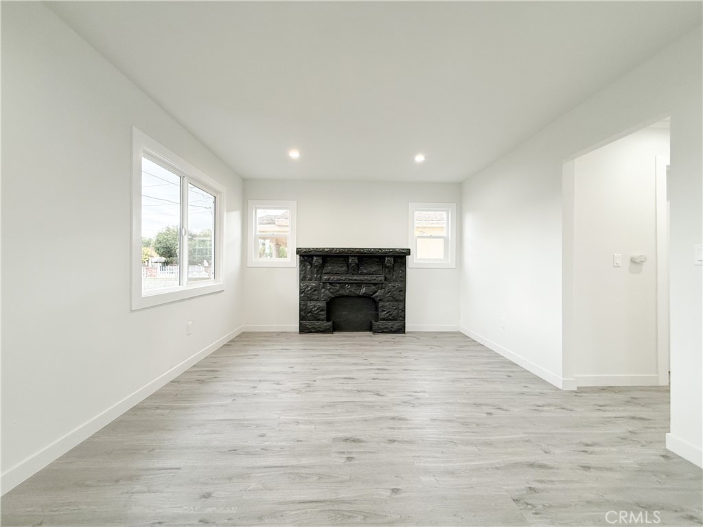 2222 East 124th Street Compton, CA 90222 - Photo 11 of 20 a view of an empty room with a fireplace and a window