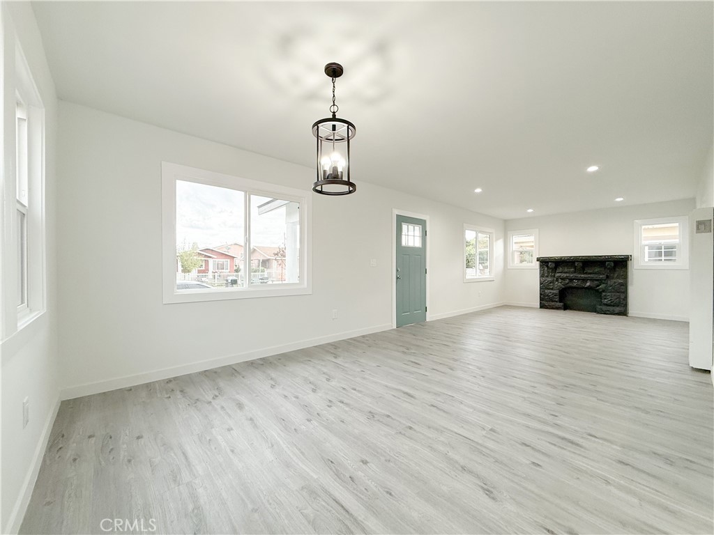 2222 East 124th Street Compton, CA 90222 - Photo 12 of 20 an empty room with wooden floor fireplace and windows