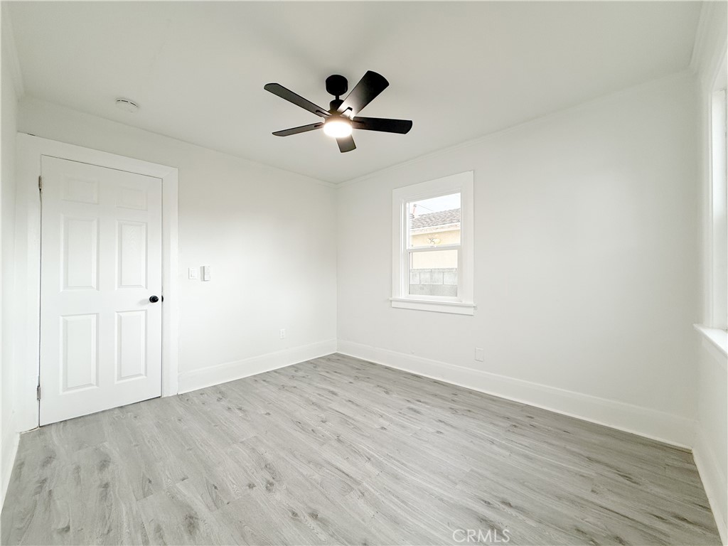 2222 East 124th Street Compton, CA 90222 - Photo 15 of 20 an empty room with wooden floor fan and windows