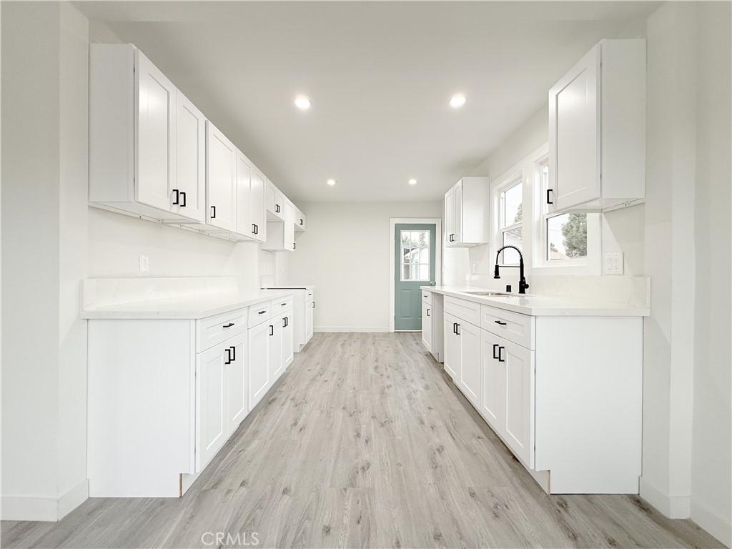 2222 East 124th Street Compton, CA 90222 - Photo 7 of 20 a kitchen with cabinets and wooden floors