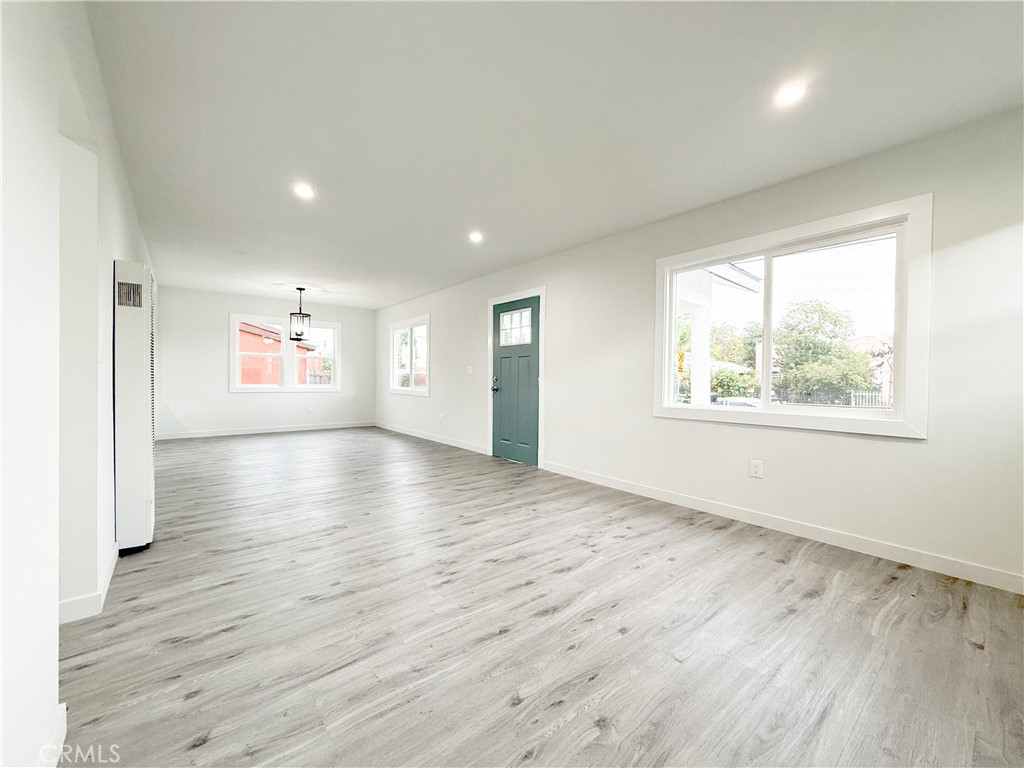 2222 East 124th Street Compton, CA 90222 - Photo 9 of 20 an empty room with wooden floor and windows