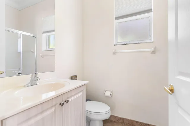 a bathroom with a sink a toilet and a mirror