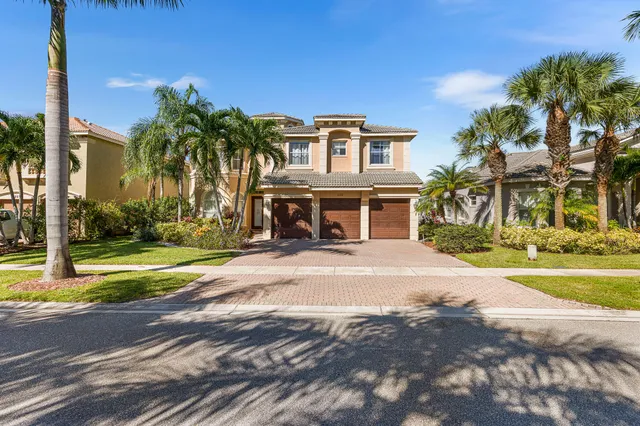 a view of a house with a yard and palm trees