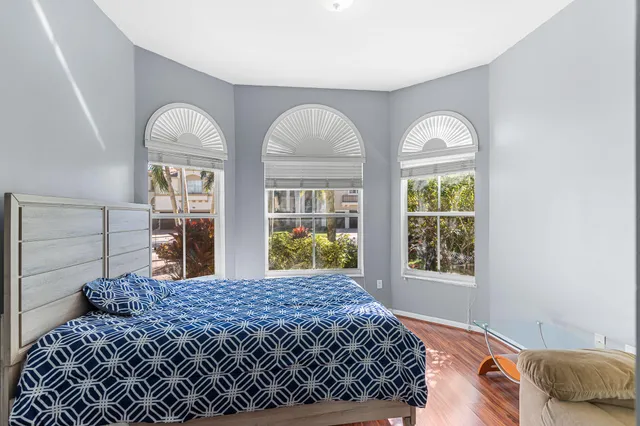 a bedroom with a large bed and two windows