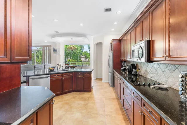 a kitchen with stainless steel appliances granite countertop a sink stove and refrigerator