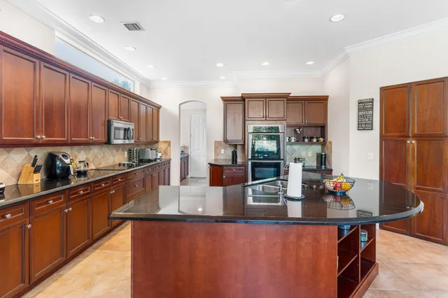 a kitchen with stainless steel appliances granite countertop a refrigerator a sink dishwasher a stove with wooden cabinets and floor