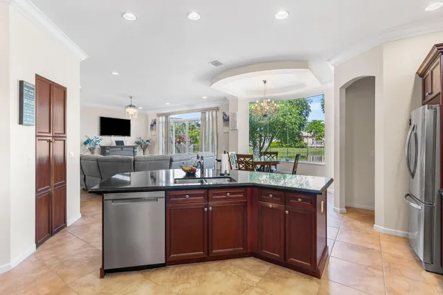 a kitchen with stainless steel appliances granite countertop a refrigerator a sink a stove a microwave and a refrigerator