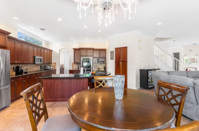 a kitchen with stainless steel appliances granite countertop a living room dining room and refrigerator