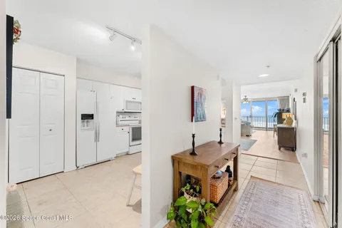 a dining room with furniture and a floor to ceiling window