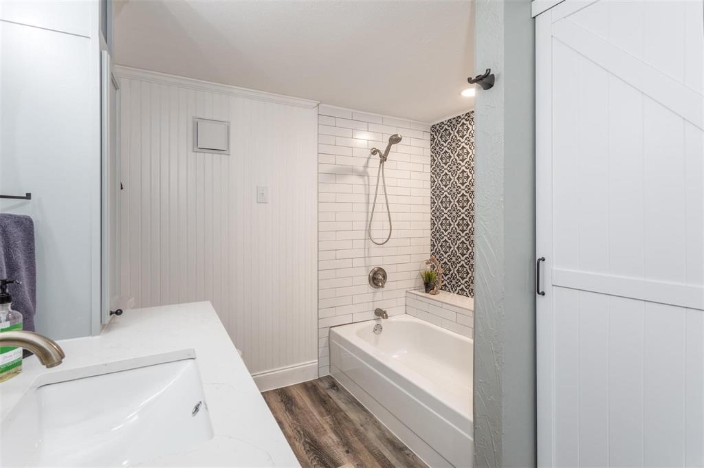 16301 Ledgemont Lane, Unit 283 Addison, TX 75001 - Photo 11 of 16 Bathroom equipped with sink, tub/shower combo, wood-like flooring.