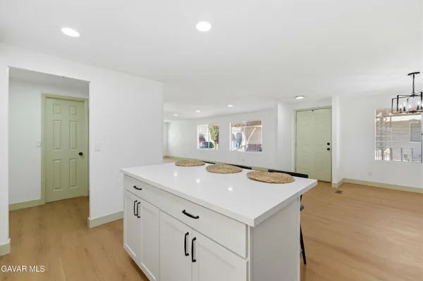 a hall with kitchen island a sink dishwasher stove with wooden floor
