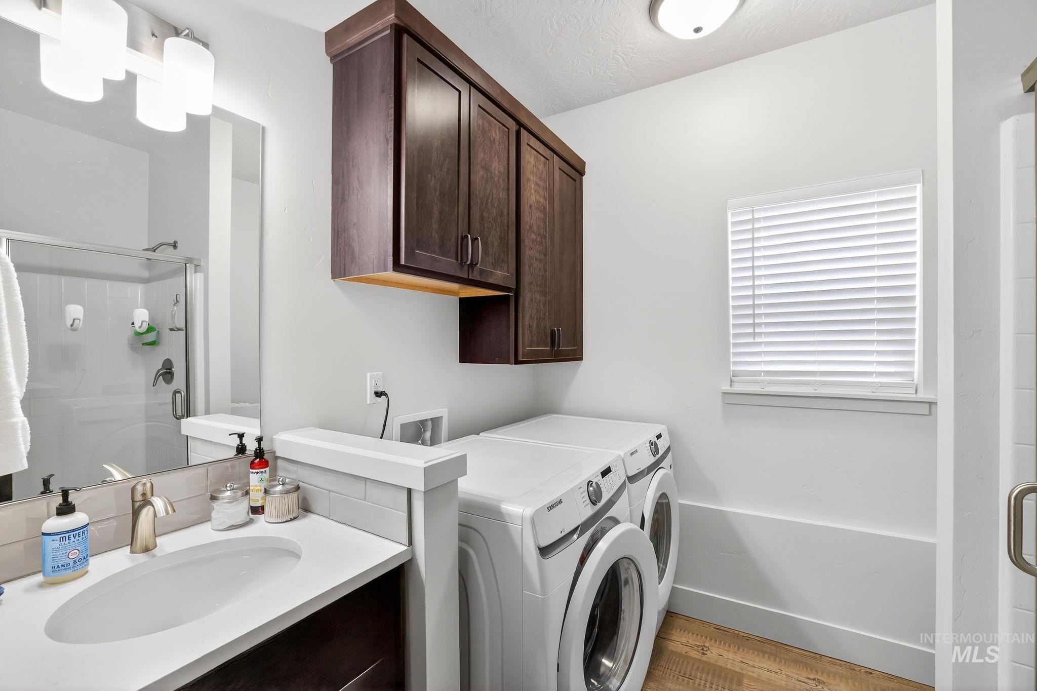 311 Broken Ridge Way McCall, ID 83638 - Photo 17 of 44 Combination bathroom and laundry area featuring a white countertop vanity with an undermount sink, brushed nickel faucet, and a large wall mirror