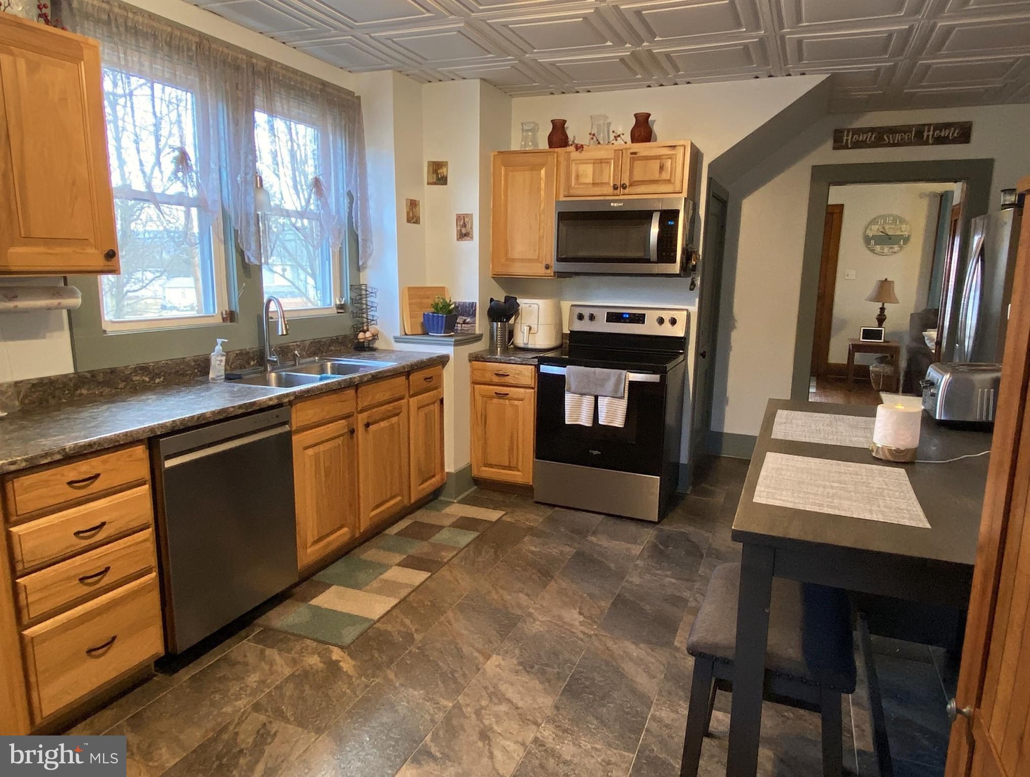 14103 Temple Street Ellerslie, MD 21529 - Photo 3 of 57 a kitchen with stainless steel appliances granite countertop a stove top oven a sink dishwasher a dining table and chairs with wooden floor