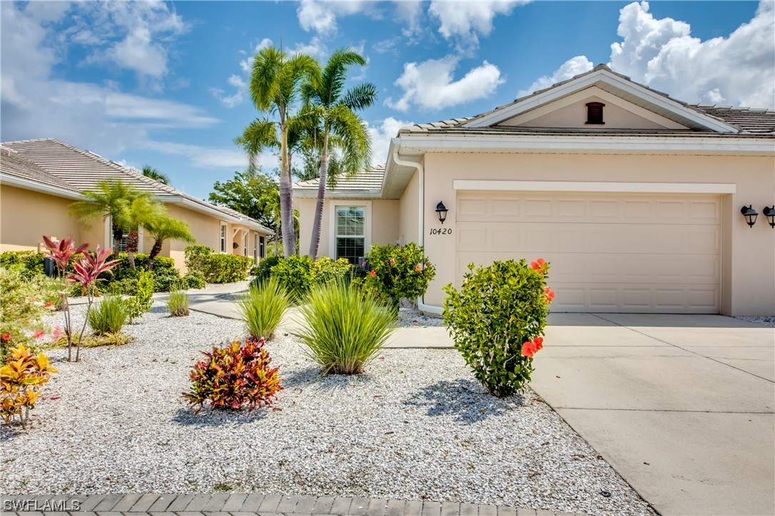 a front view of a house with a yard and a garden
