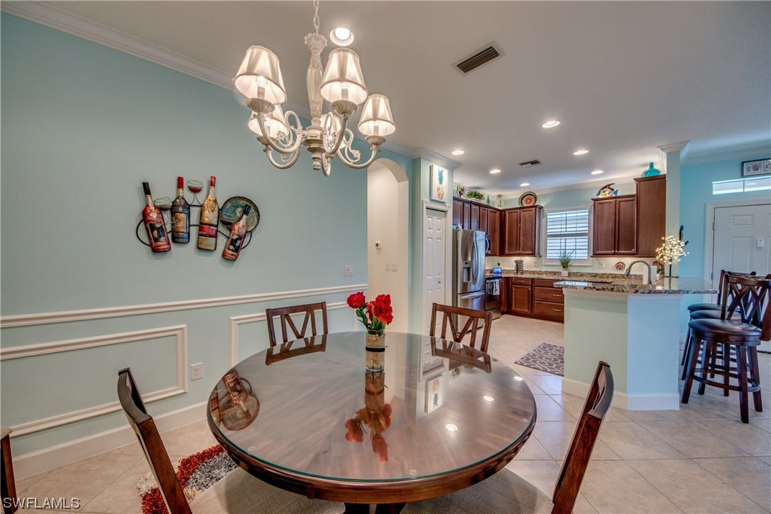 10420 Peso Del Rio Drive Fort Myers, FL 33908 - Photo 11 of 50 a view of a dining room with furniture a chandelier and wooden floor