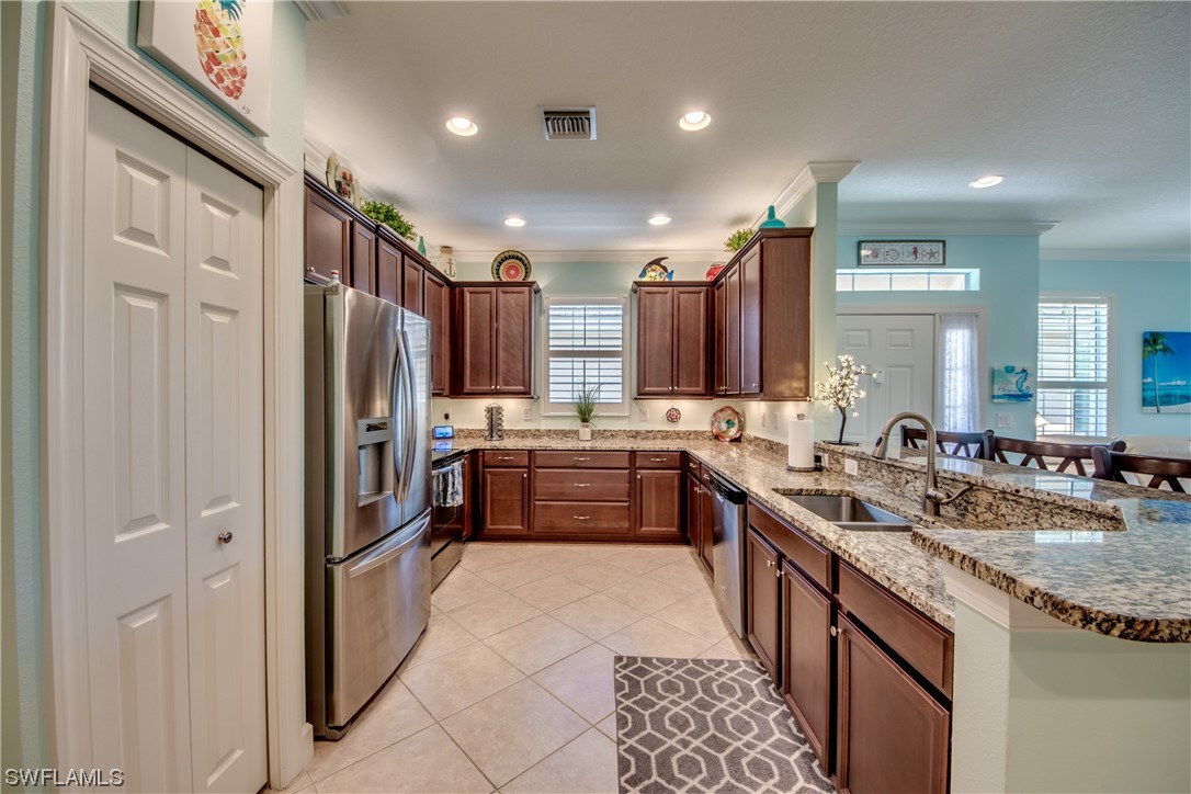 10420 Peso Del Rio Drive Fort Myers, FL 33908 - Photo 15 of 50 a large kitchen with stainless steel appliances lots of counter space and a sink