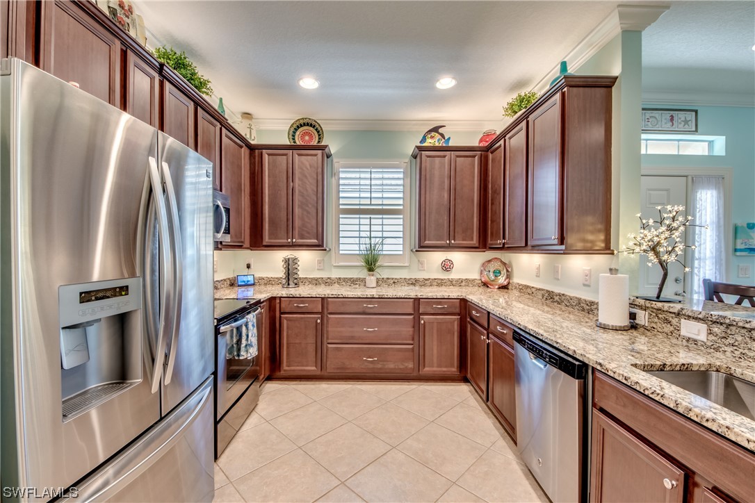 10420 Peso Del Rio Drive Fort Myers, FL 33908 - Photo 16 of 50 a large kitchen with granite countertop a sink stove and refrigerator