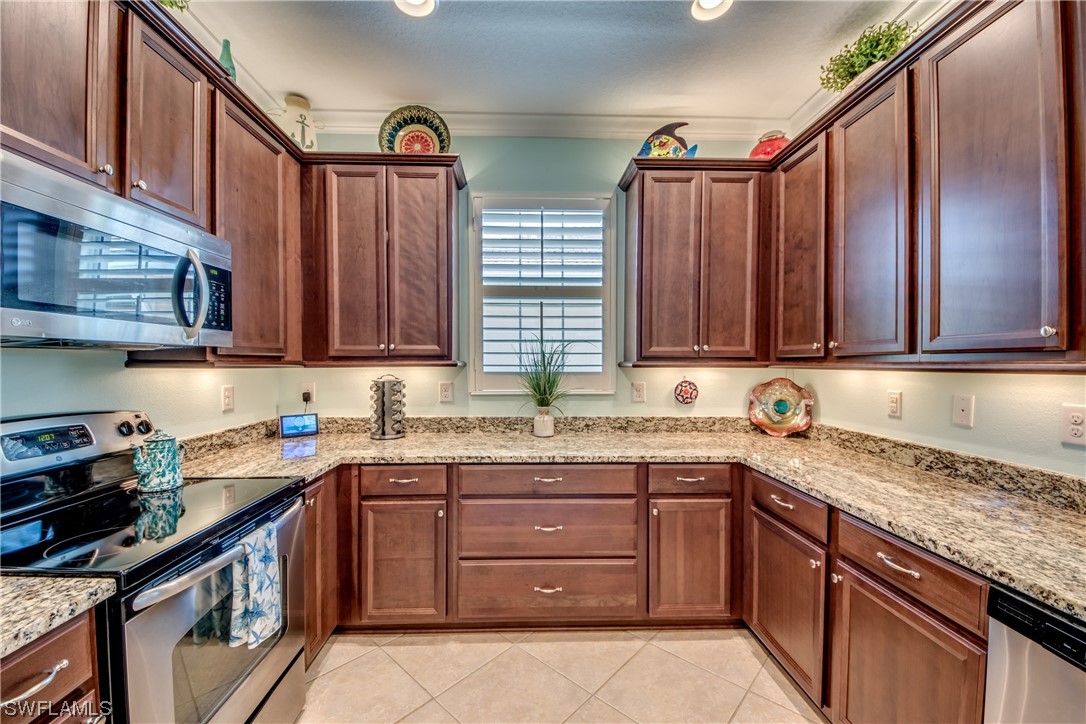 10420 Peso Del Rio Drive Fort Myers, FL 33908 - Photo 18 of 50 a kitchen with stainless steel appliances granite countertop a sink stove and cabinets